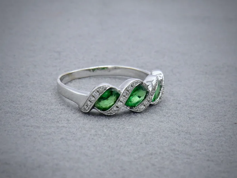 Green Tsavorite and diamond ring in white metal with a twist design