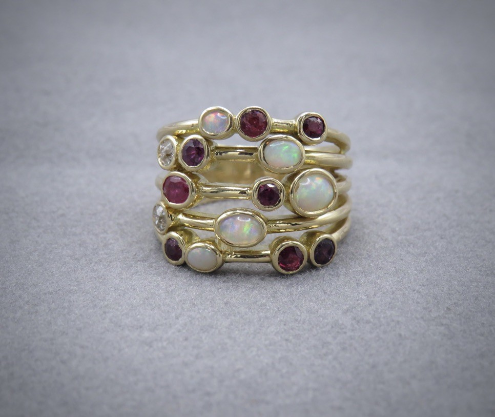 Opal, diamond and ruby asymmetrical ring on gold bands