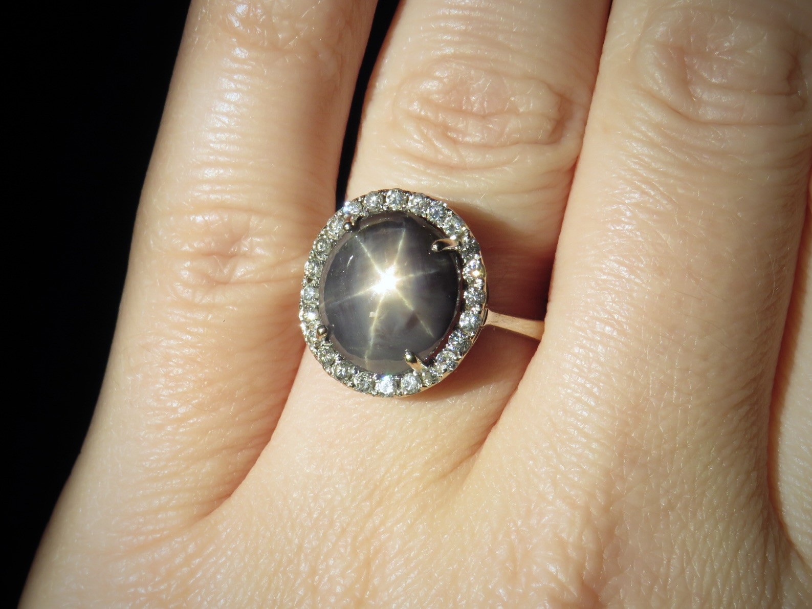 Gray star sapphire ring on a finger